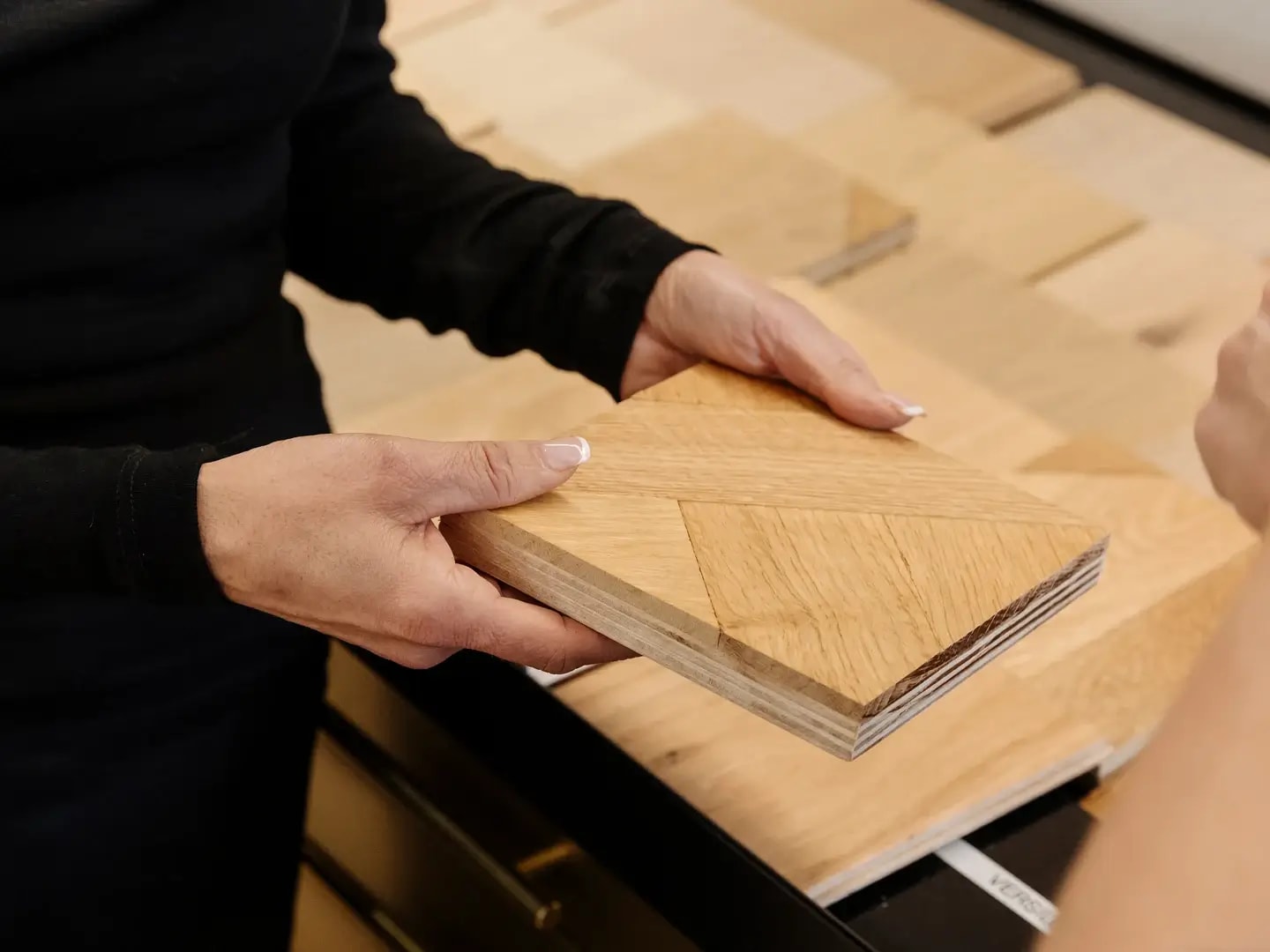 Havwoods showroom manager showing a flooring sample to a client.